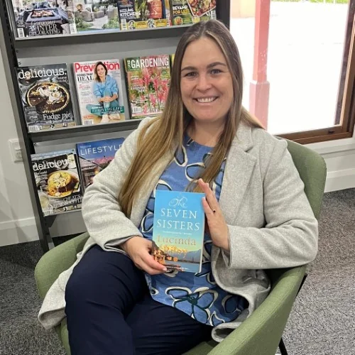 A library staff member displays The Seven Sisters in the library.