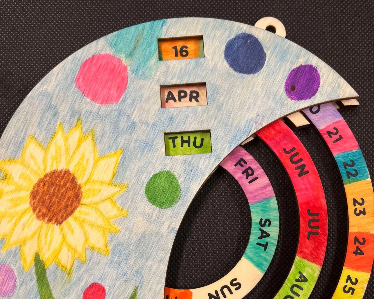 A rotating wooden calendar that has been decorated by hand.