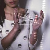 Image of woman playing with string game cat's cradle
