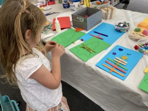 Image shows a child doing Christmas craft at Holbrook Library