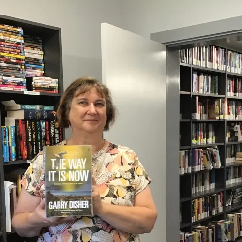 A librarian holds up The Way it Is Now by Garry Disher