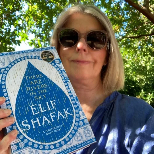 A library staff member displays There are Rivers in the Sky by Elif Shafak