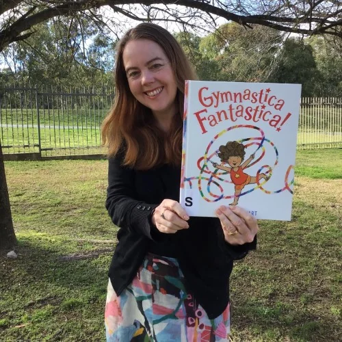 A library staff member holds up Gymnastica Fantastica!