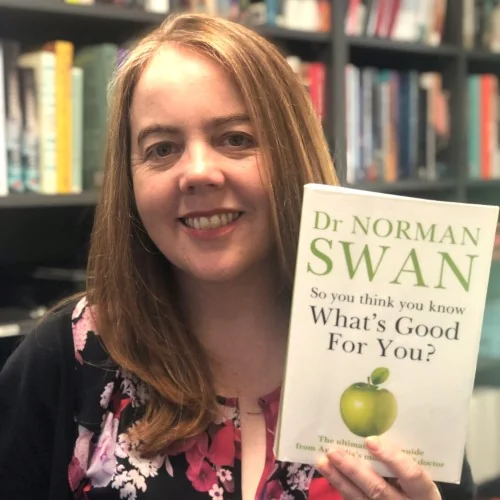 A library staff member poses with So you think you know what's good for you? by Dr Norman Swan.