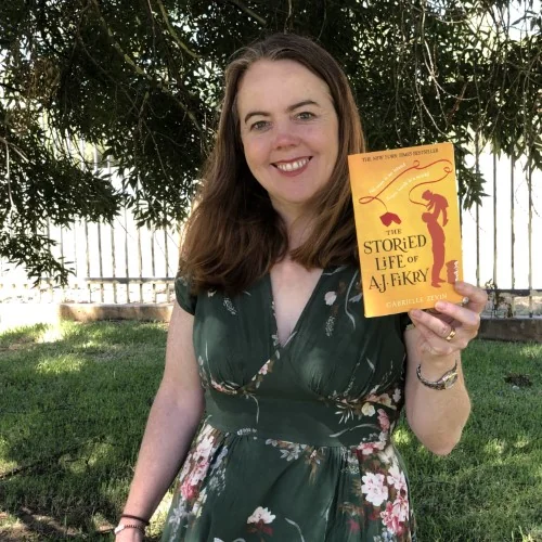 A library staff member holds up The Storied Life of AJ Fikry.