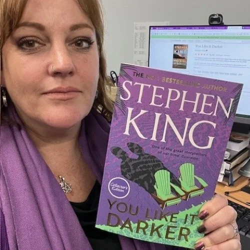 A library staff member displays You Like it Darker by Stephen King