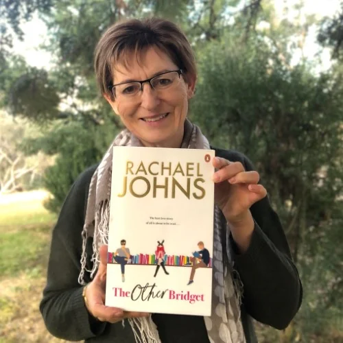 A library staff member poses with The Other Bridget by Rachael Johns