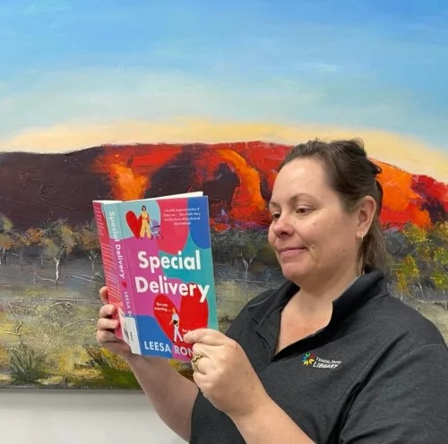 A library staff member reads Special Delivery by Leesa Ronald