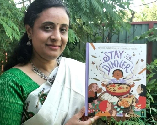 Author Sandhya Parappukkaran poses with her children's picture book, book Stay for Dinner