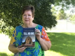 Tracey holding up a copy of Tell No One by Brendan Watkins