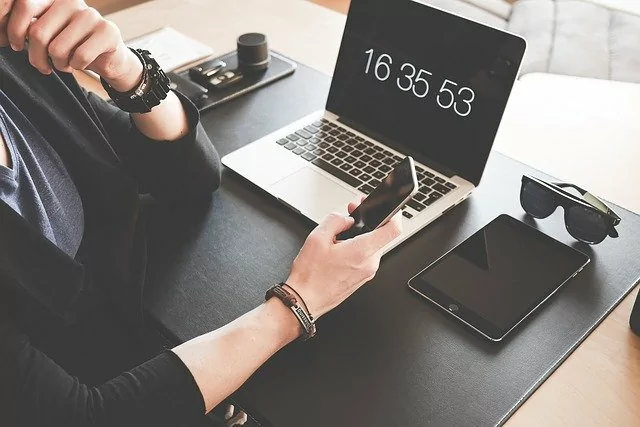 Image of a laptop, iPad and smart phone sitting on a desk