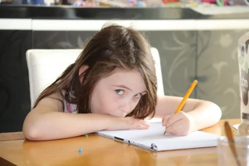 Image of child writing in a notepad